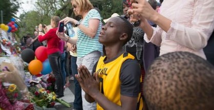 Un hombre se arrodilla y reza ante flores, velas y mensajes de despedida colocados como homenaje al ex presidente sudafricano y premio Nobel de Paz Nelson Mandela delante de la casa donde murió, en Houghton, Sudáfrica, el pasado 7 de diciembre.