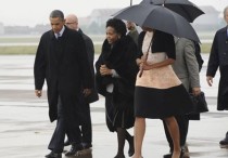 Fotografía distribuida por el Ministerio de Asuntos Exteriores de Sudáfrica que muestra el momento de la llegada del presidente de Estados Unidos, Barack Obama (i), de su predecesor, George W. Bush (d), y de su esposa, Michelle Obama (cubierta por un paraguas), a la base aérea Waterkloof de Pretoria, donde fueron recibidos por la ministra sudafricana de Relaciones Exteriores, Maite Nkoana-Mashabane (c). EFE