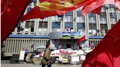 Varias banderas ondean delante de la sede del Servicio de Seguridad, ocupada por activistas prorrusos, en Lugansk (Ucrania). EFE
