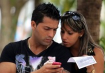Dos jóvenes usan un teléfono móvil, en La Habana (Cuba). EFE/Archivo