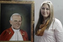 Floribeth Mora, la mujer costarricense que fue sanada de un aneurisma cerebral por medio de un milagro que se le atribuye a Juan Pablo II posa junto a una pintura del "papa viajero", durante una rueda de prensa, antes de partir a Roma a la canonización de Juan Pablo II. EFE
