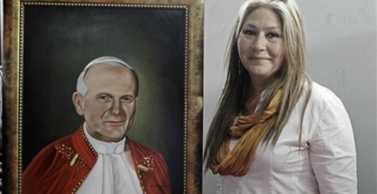 Floribeth Mora, la mujer costarricense que fue sanada de un aneurisma cerebral por medio de un milagro que se le atribuye a Juan Pablo II posa junto a una pintura del "papa viajero", durante una rueda de prensa, antes de partir a Roma a la canonización de Juan Pablo II. EFE