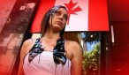 En la imagen una mujer protesta delante de la bandera canadiense con barro y petróleo sobre su cabeza